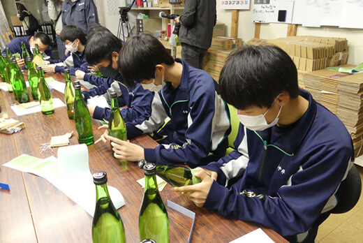 「旭農高日本酒プロジェクト 兆(きざし)2022」のラベル貼りを行う生徒のみなさん