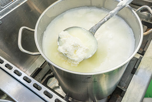 牛が出産した直後から出る牛乳（初乳）を湯せんにかけ、酢で固めた様子。